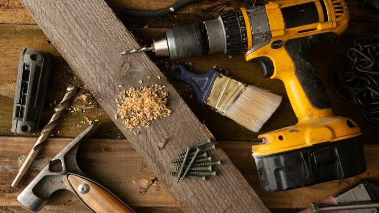 Contractor power tools and hand tools laid out on a workbench.